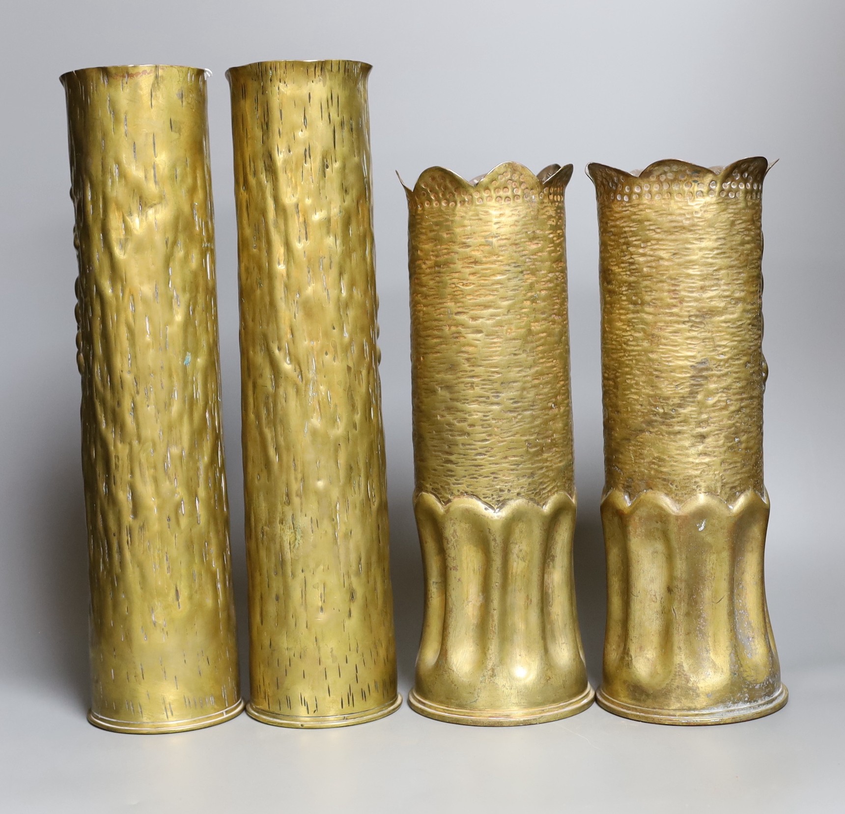 Four decorative carved brass shell cases, tallest 35cm
